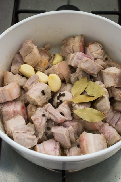 pork belly with garlic cloves, bay leaves and whole black peppercorns