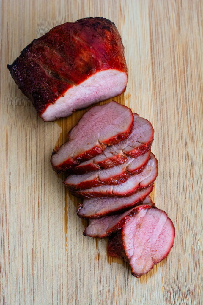 char siu sliced on a wooden cutting board