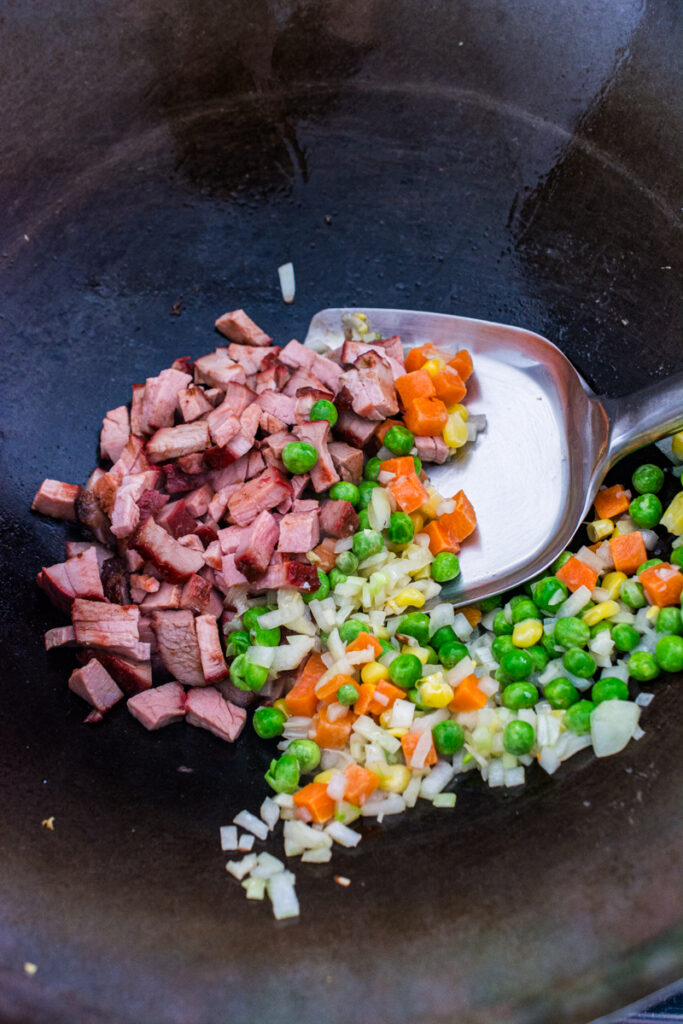 char siu pork and veggies in a wok for fried rice